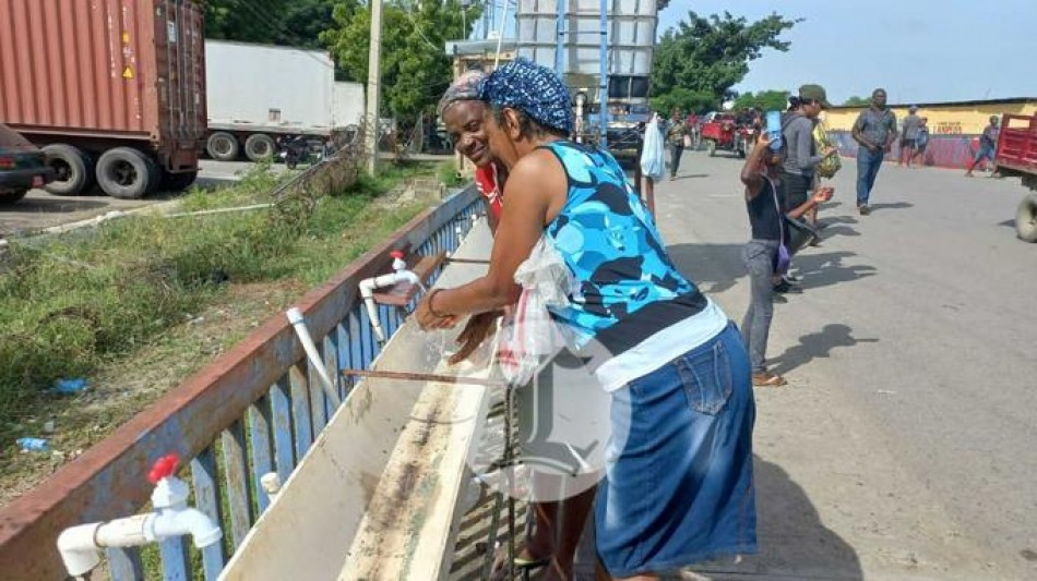Haitianos se lavan las manos antes de entrar al mercado de Dajab&oacute;n para evitar el c&oacute;lera